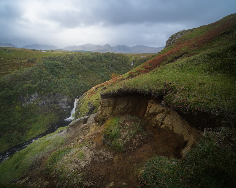 montaña verde y marrón bajo nubes blancas durante el día