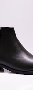 black leather boot on white table