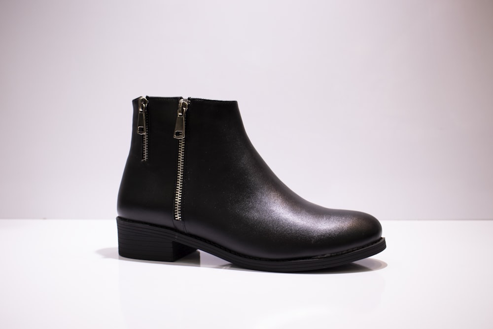 Botte en cuir noir sur table blanche