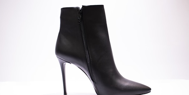 black leather boot on white surface