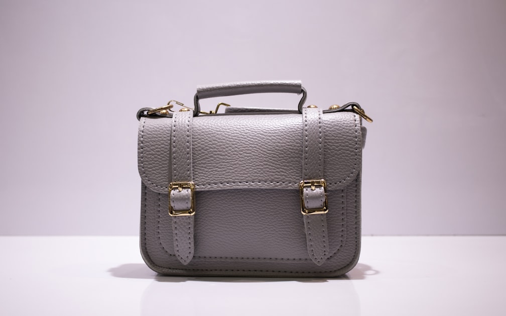 Close-up of a leather satchel with gold hardware, evoking the tactile elegance of artisanal bag construction.