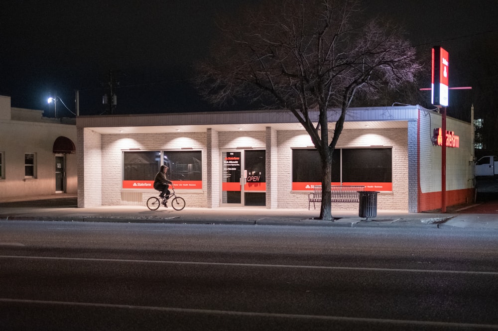 white and brown concrete building near bare trees during night time