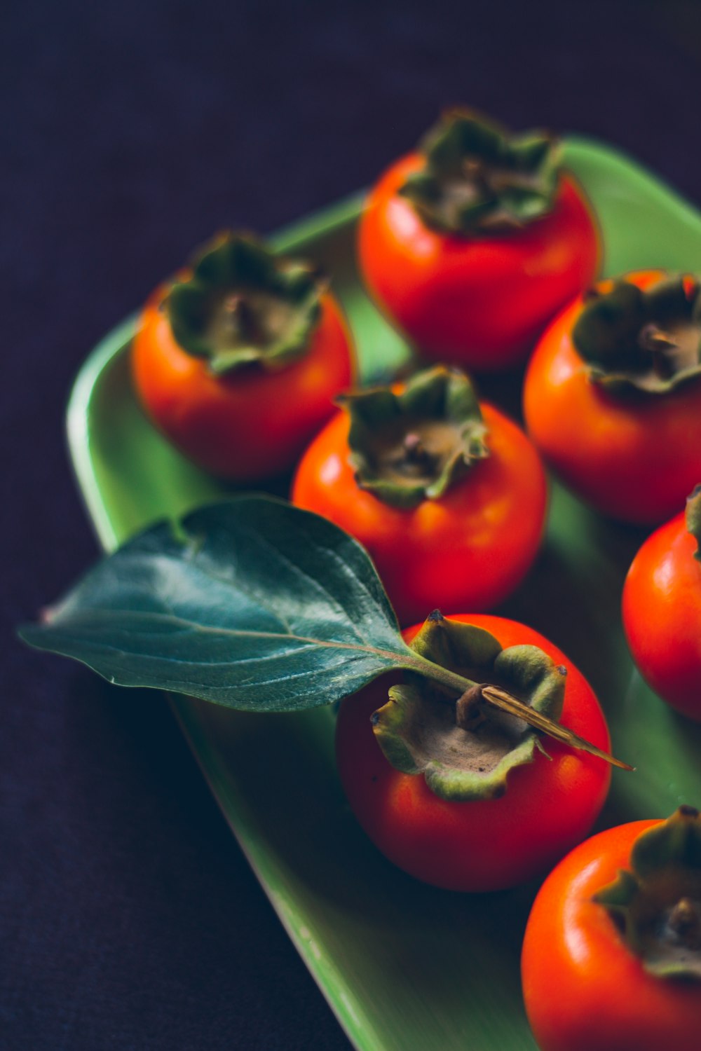 red tomatoes on green ceramic plate