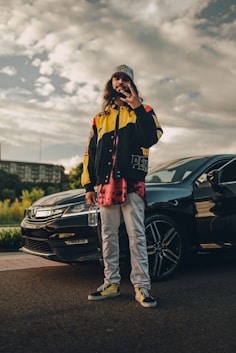 woman in black jacket and pants standing beside black car