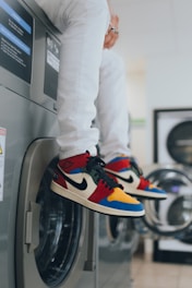 person in white pants wearing black and red nike sneakers
