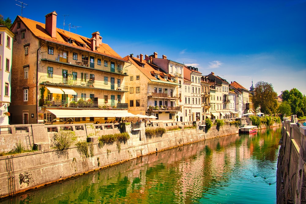 Weiße und braune Betongebäude am Fluss tagsüber