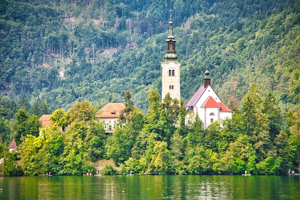 white and brown concrete building near green trees and body of water during daytime