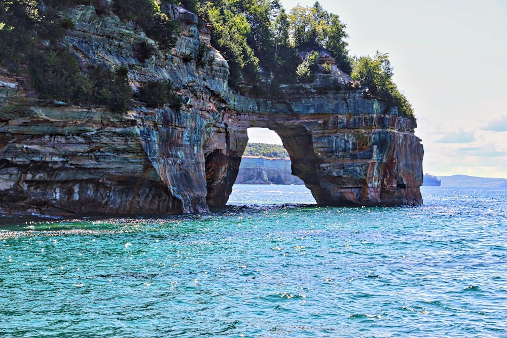 brown rock formation on body of water during daytime