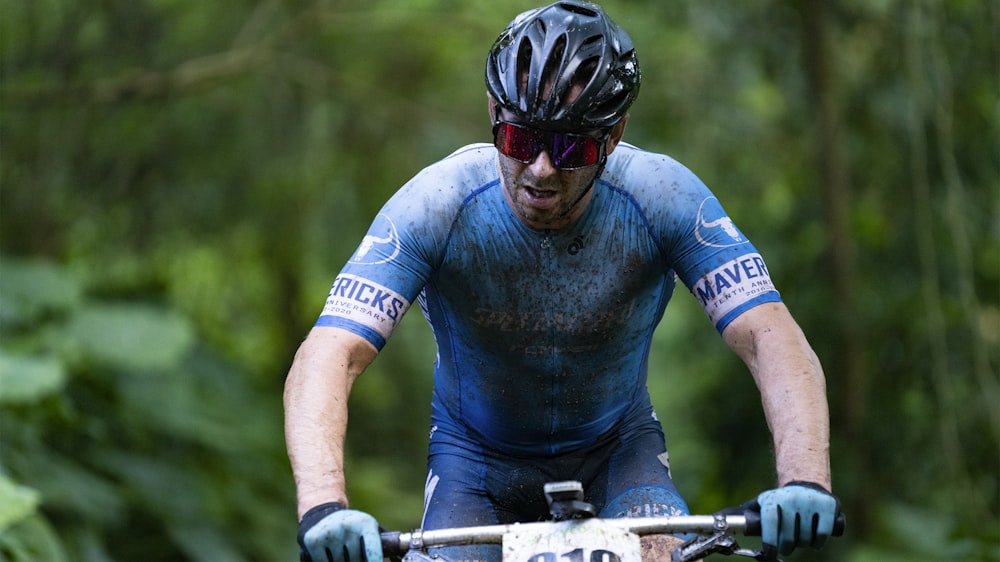 man in blue long sleeve shirt riding on bicycle