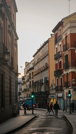 cars parked on side of the road in between buildings during daytime