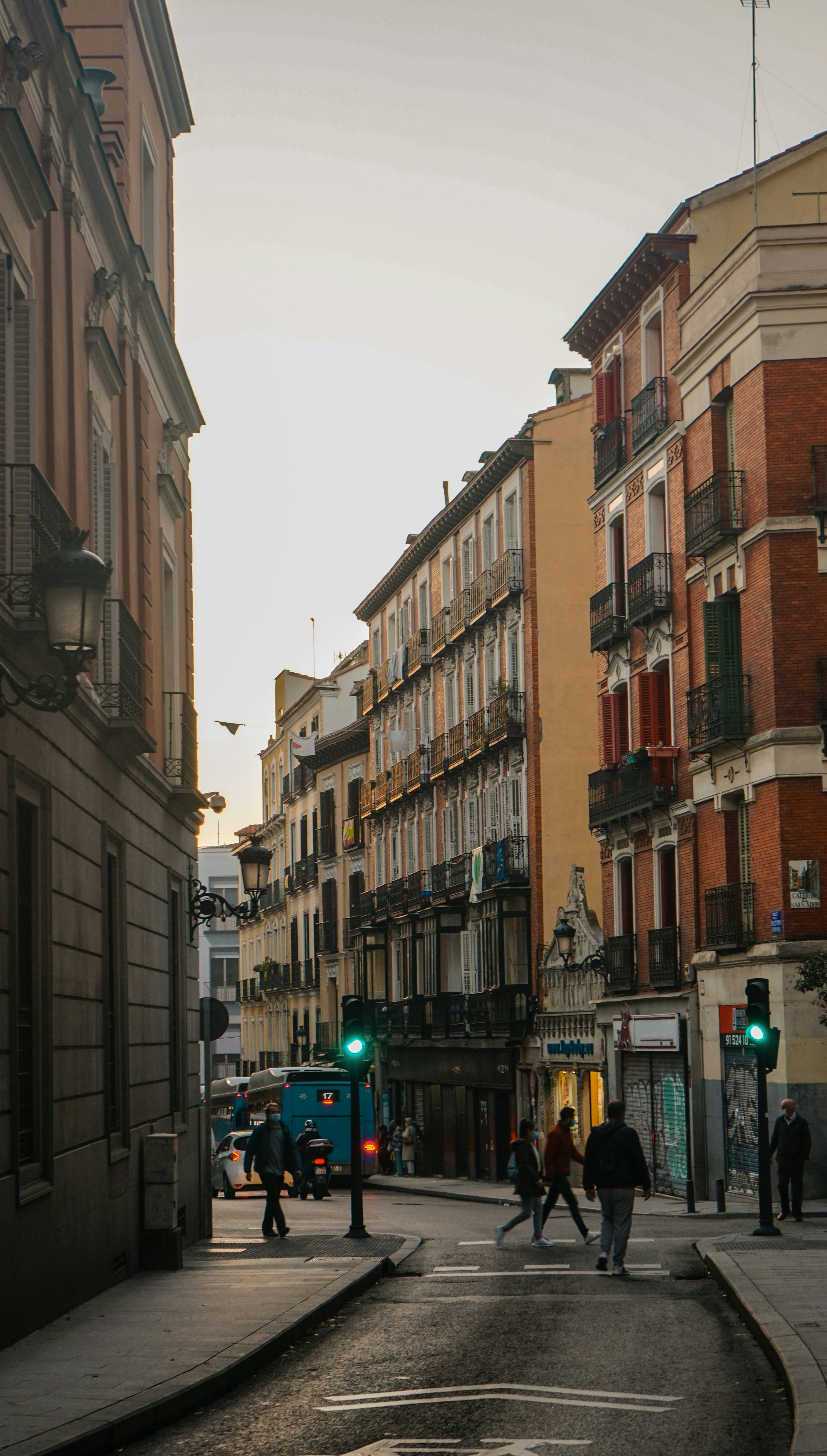 cars parked on side of the road in between buildings during daytime