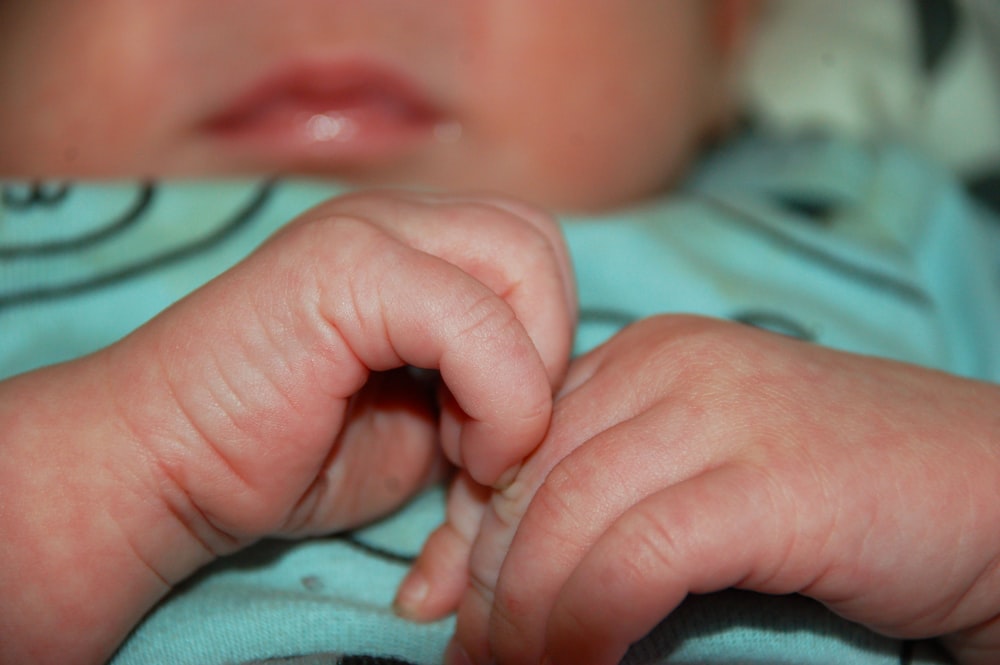 babys hand on blue textile