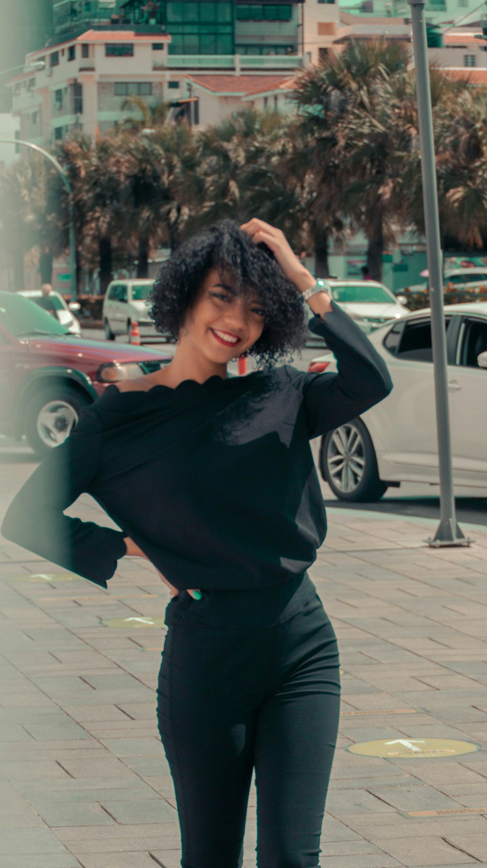 woman in black long sleeve shirt standing near red car during daytime