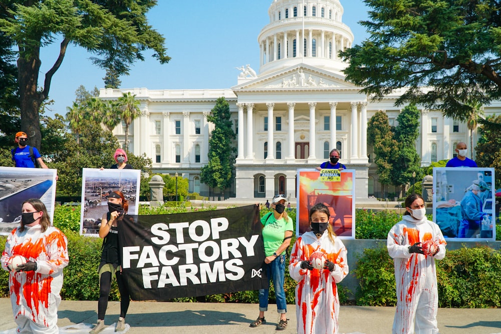 a group of people holding signs in front of a building