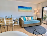 Cozy interior corner featuring woven cushions and beach-themed decor.