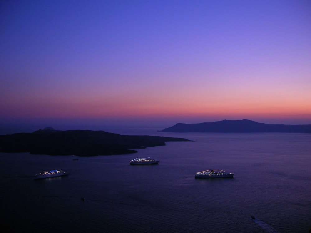 white boat on sea during sunset