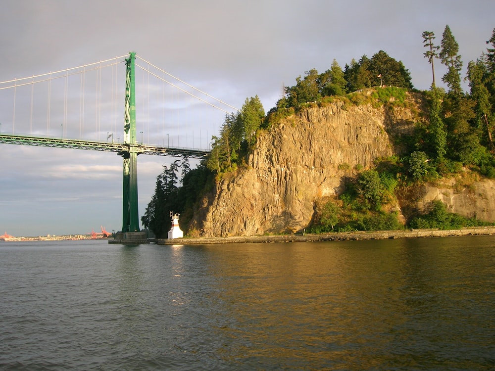 bridge over river near mountain during daytime