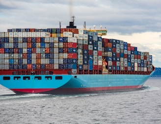 blue and red cargo ship on sea during daytime