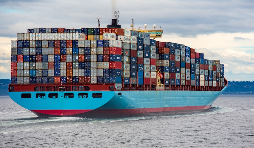 blue and red cargo ship on sea during daytime