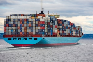 blue and red cargo ship on sea during daytime