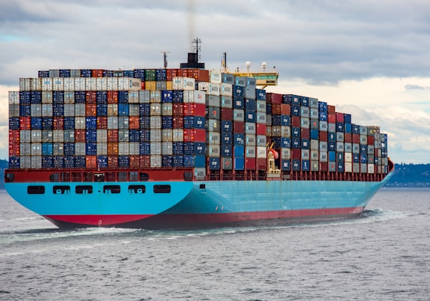 blue and red cargo ship on sea during daytime