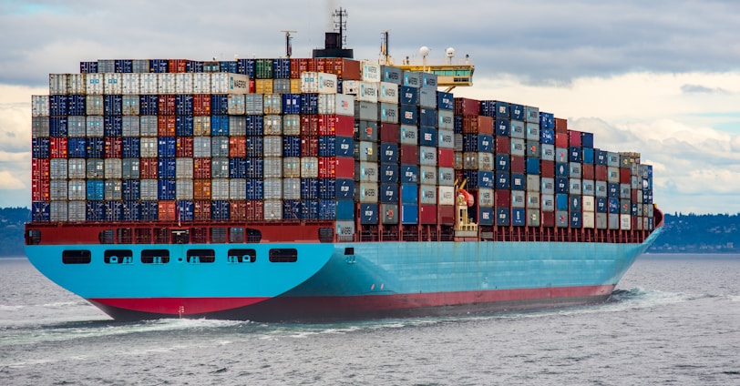 blue and red cargo ship on sea during daytime