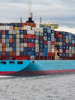 blue and red cargo ship on sea during daytime
