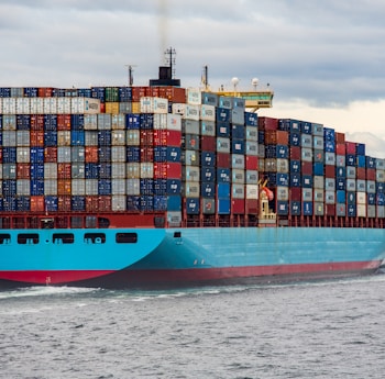 blue and red cargo ship on sea during daytime