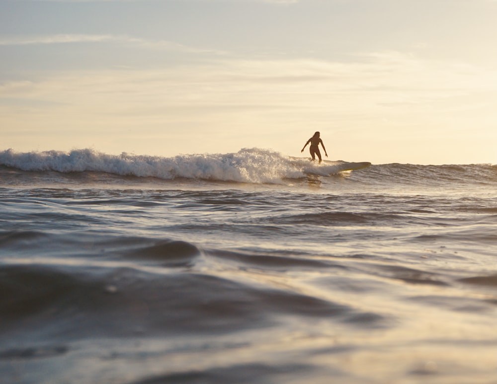 person surfing on sea waves during daytime