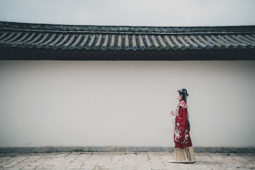 woman in red and white dress standing on gray concrete floor during daytime