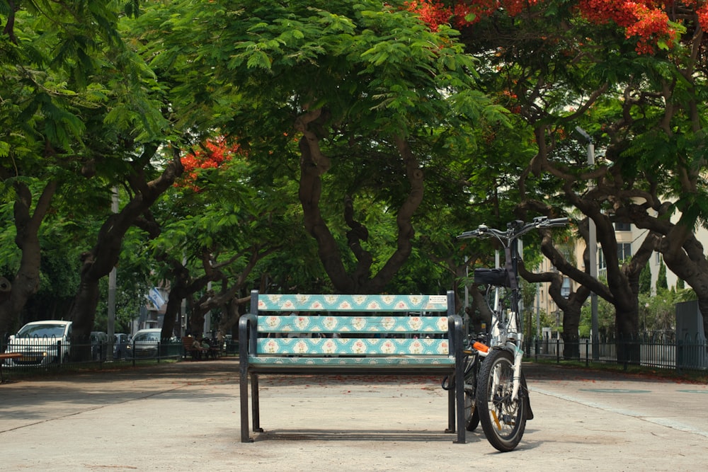 black bicycle parked beside green tree during daytime