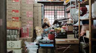 woman in blue and white dress standing beside brown cardboard boxes