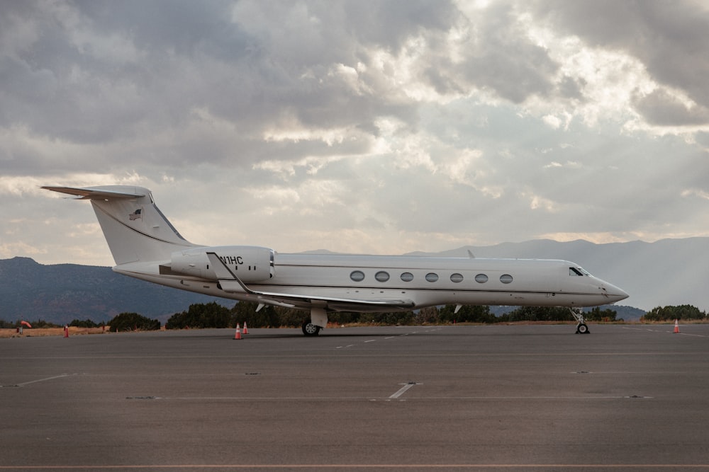 avião de passageiros branco no campo marrom sob nuvens brancas durante o dia