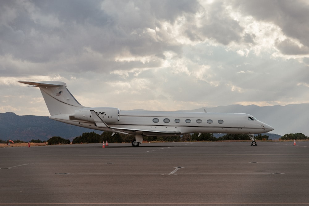 white passenger plane on brown field under white clouds during daytime