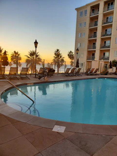 Outdoor pool area at sunset with clean, well-maintained surroundings and happy guests