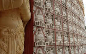 Close-up of a finely carved Indian sandstone mandir with intricate floral patterns.