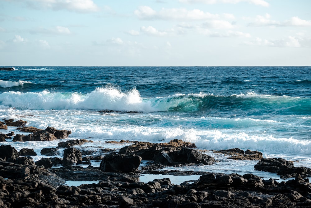 ocean waves crashing on rocks during daytime