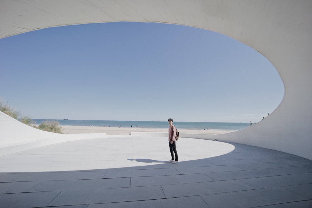 woman in black dress walking on white concrete floor during daytime