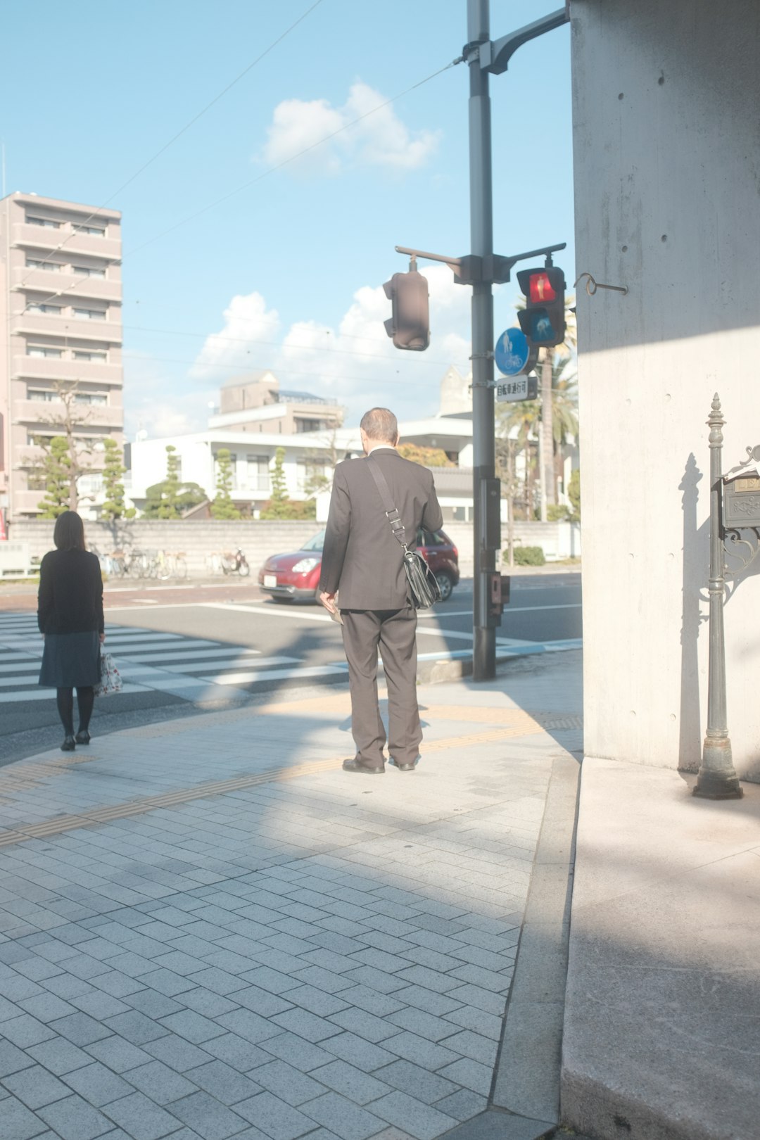 man in brown long sleeve shirt and white pants walking on sidewalk during daytime