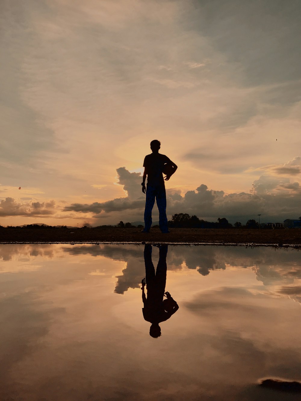 silhouette of man and woman standing on seashore during sunset