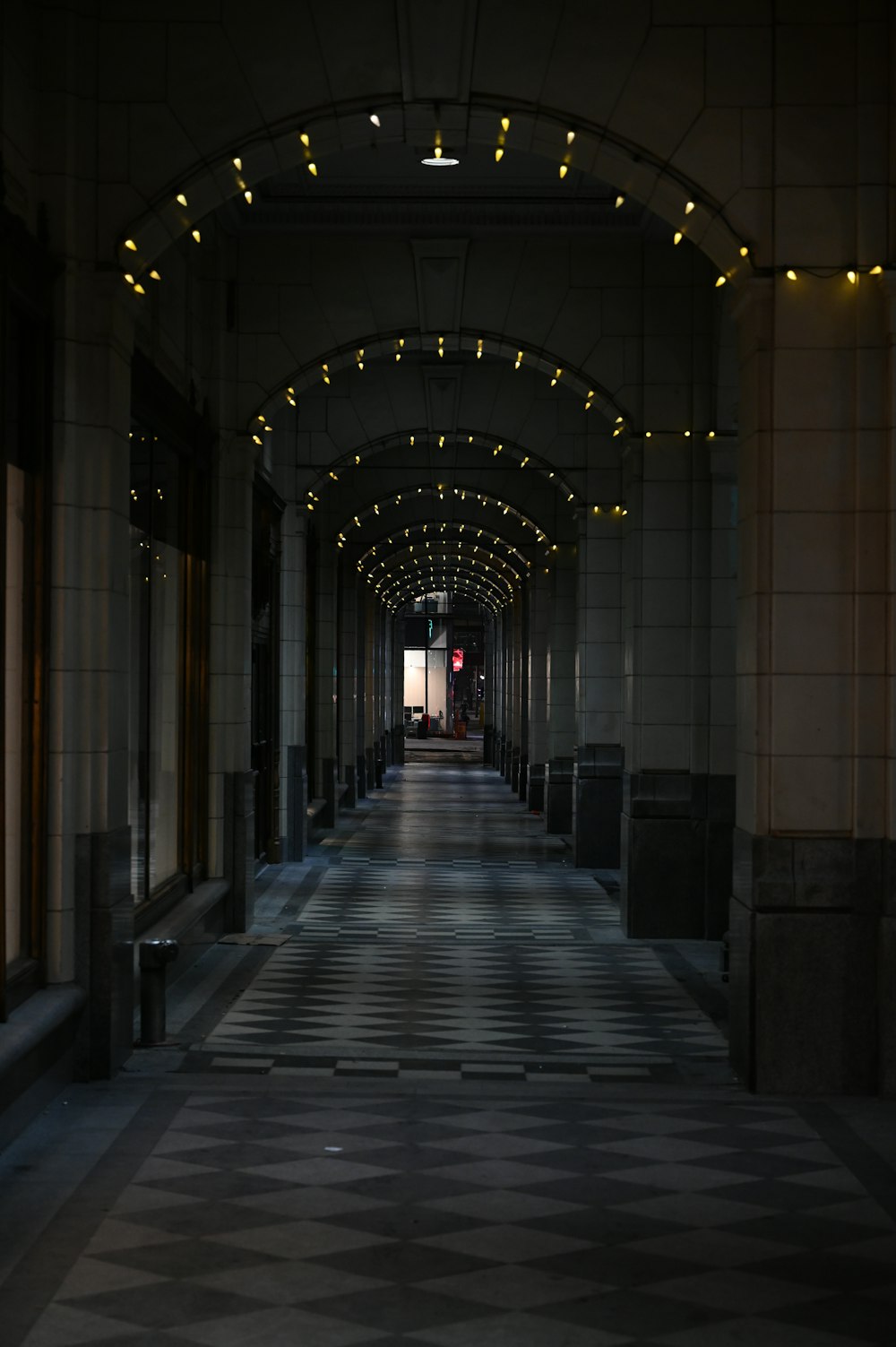 people walking on hallway with lights turned on during night time