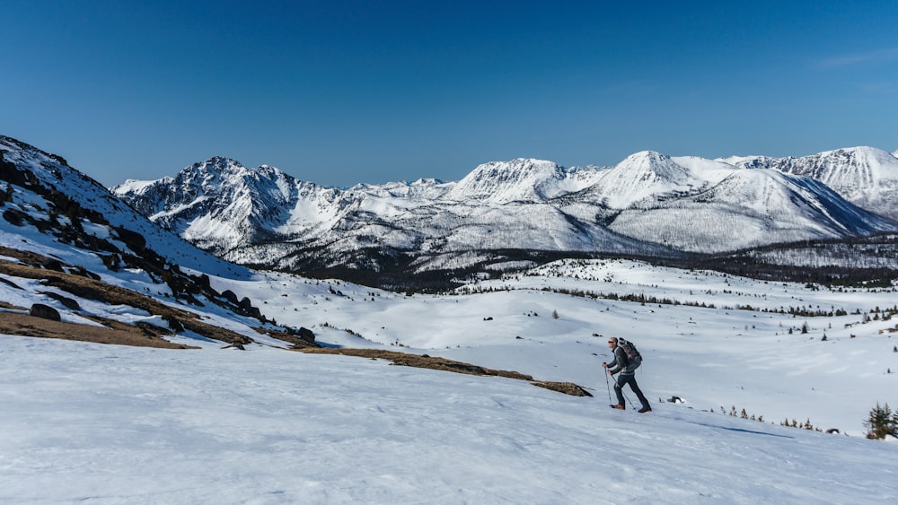 person walking on snow covered field during daytime