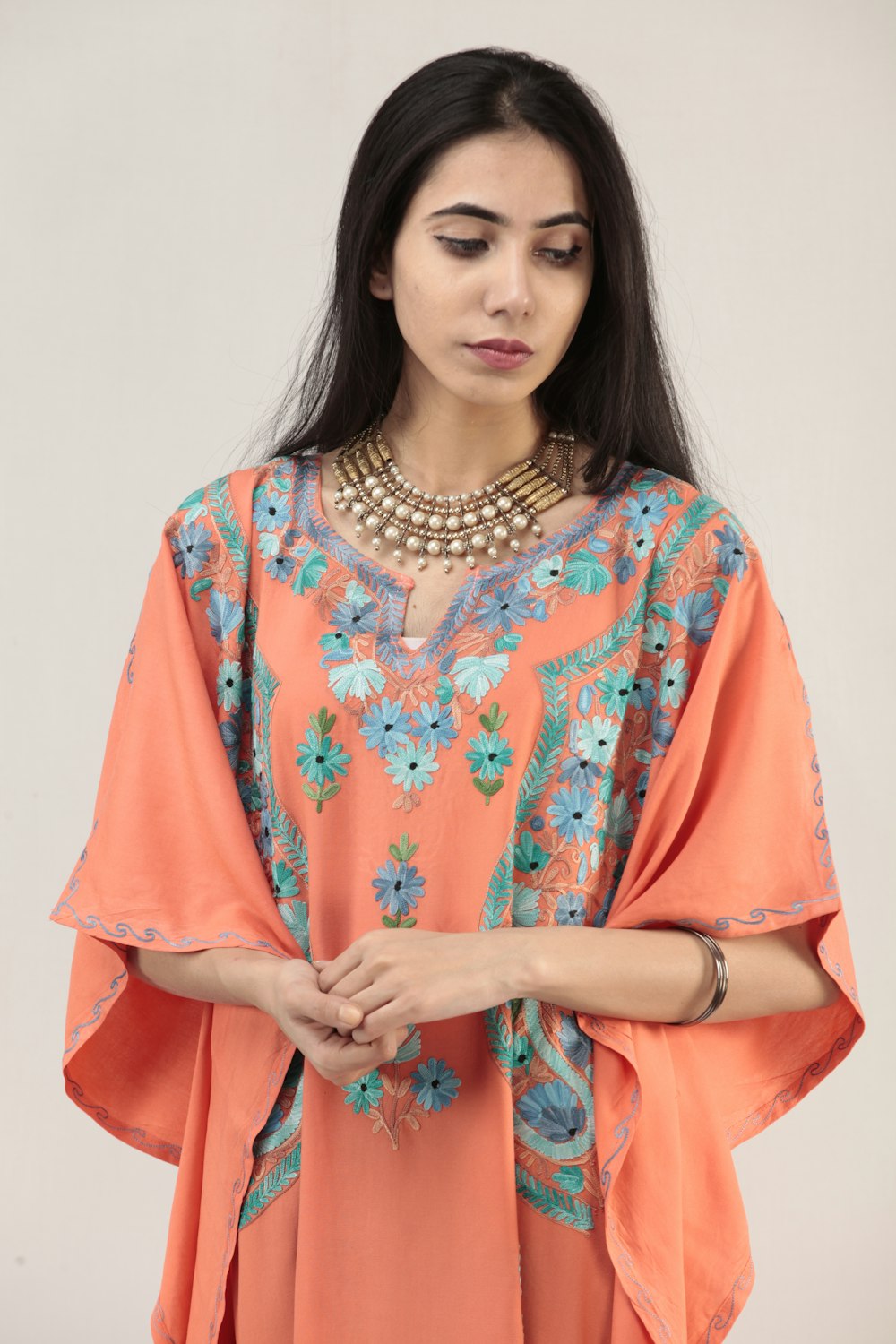 woman in orange and white floral long sleeve dress