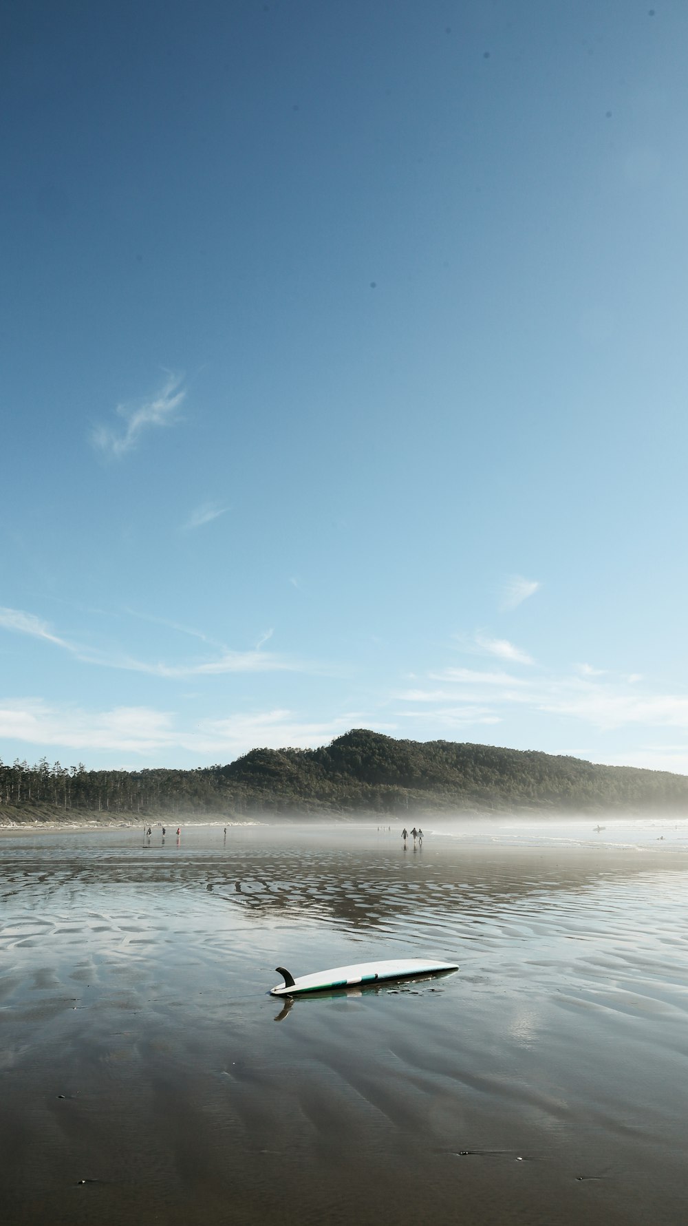 body of water near mountain under blue sky during daytime