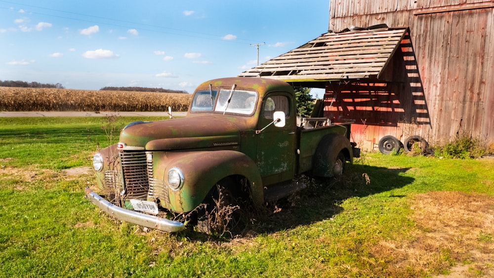 green single cab pickup truck parked on green grass field during daytime