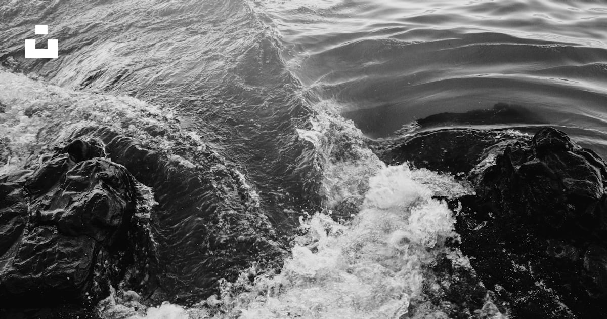Water waves hitting rocks in grayscale photography photo Free Grey