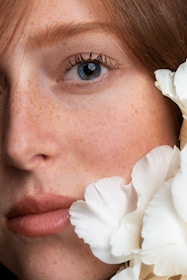 woman with white flower on her ear