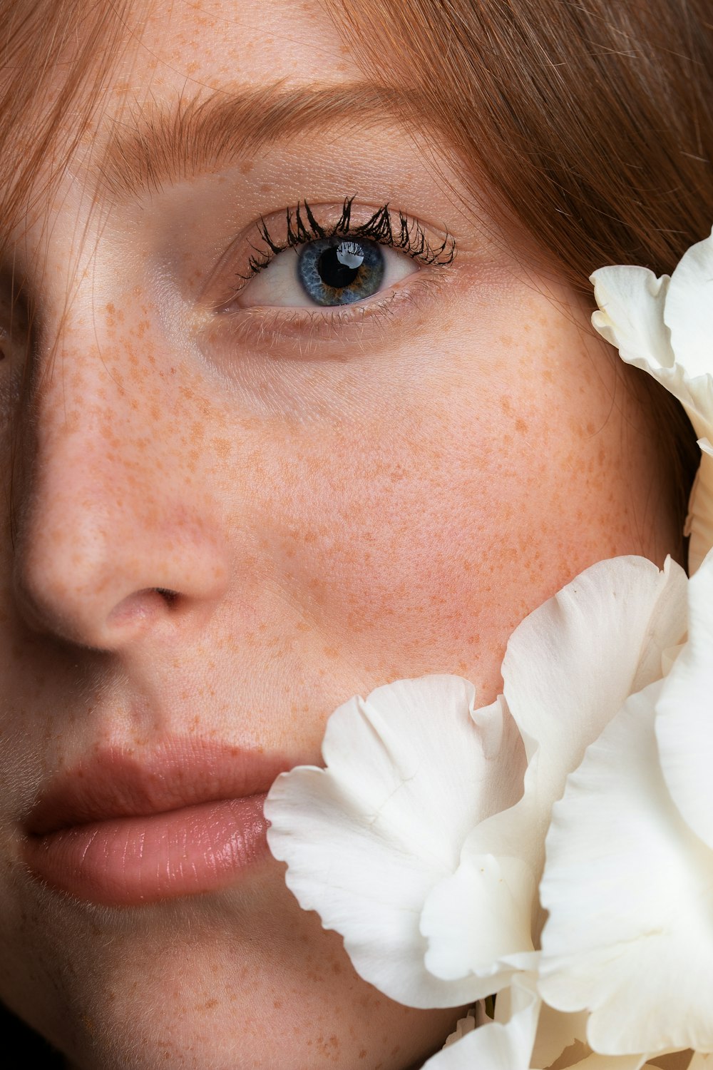 femme avec une fleur blanche sur son oreille