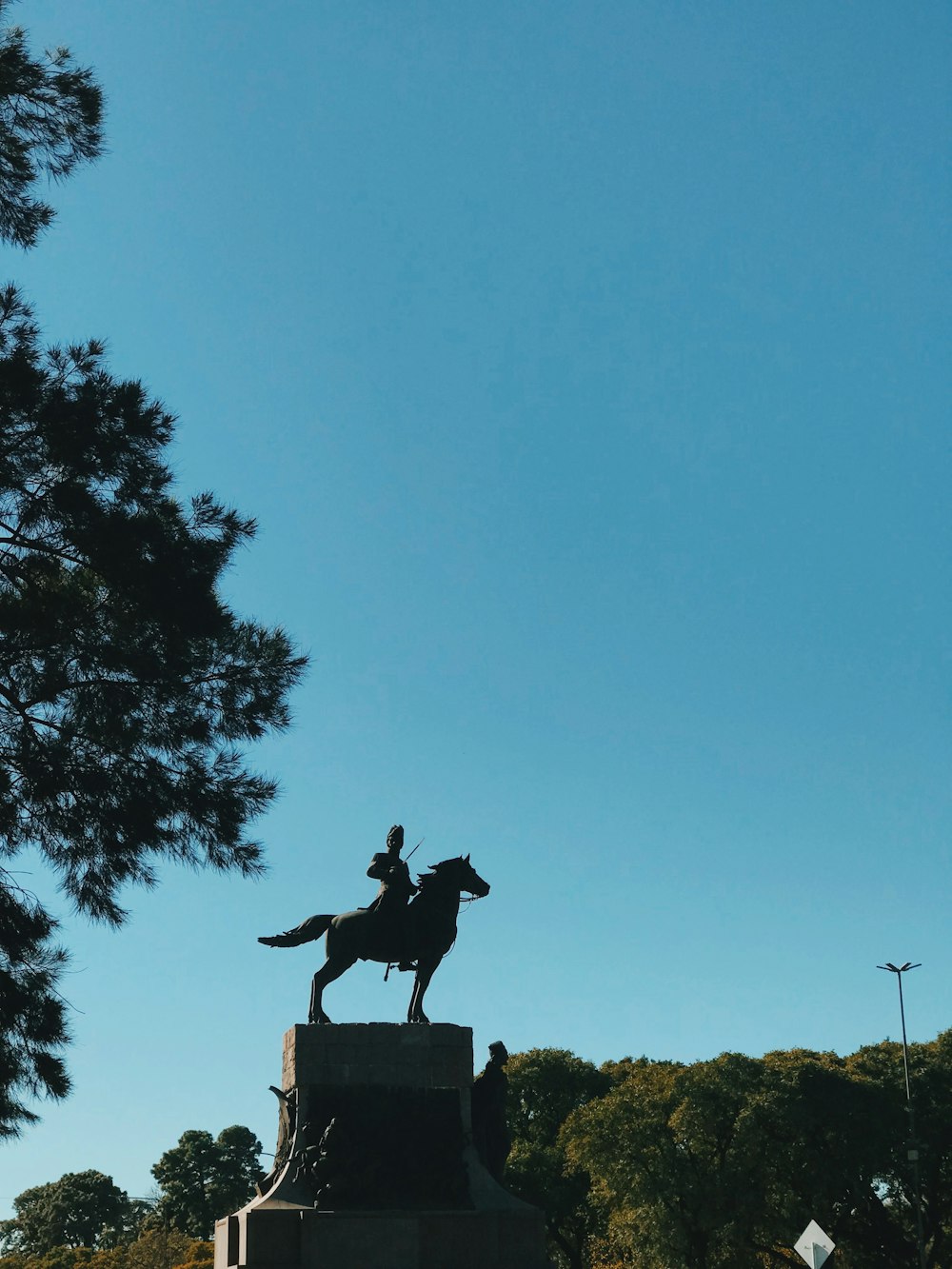 estátua preta do homem que monta o cavalo