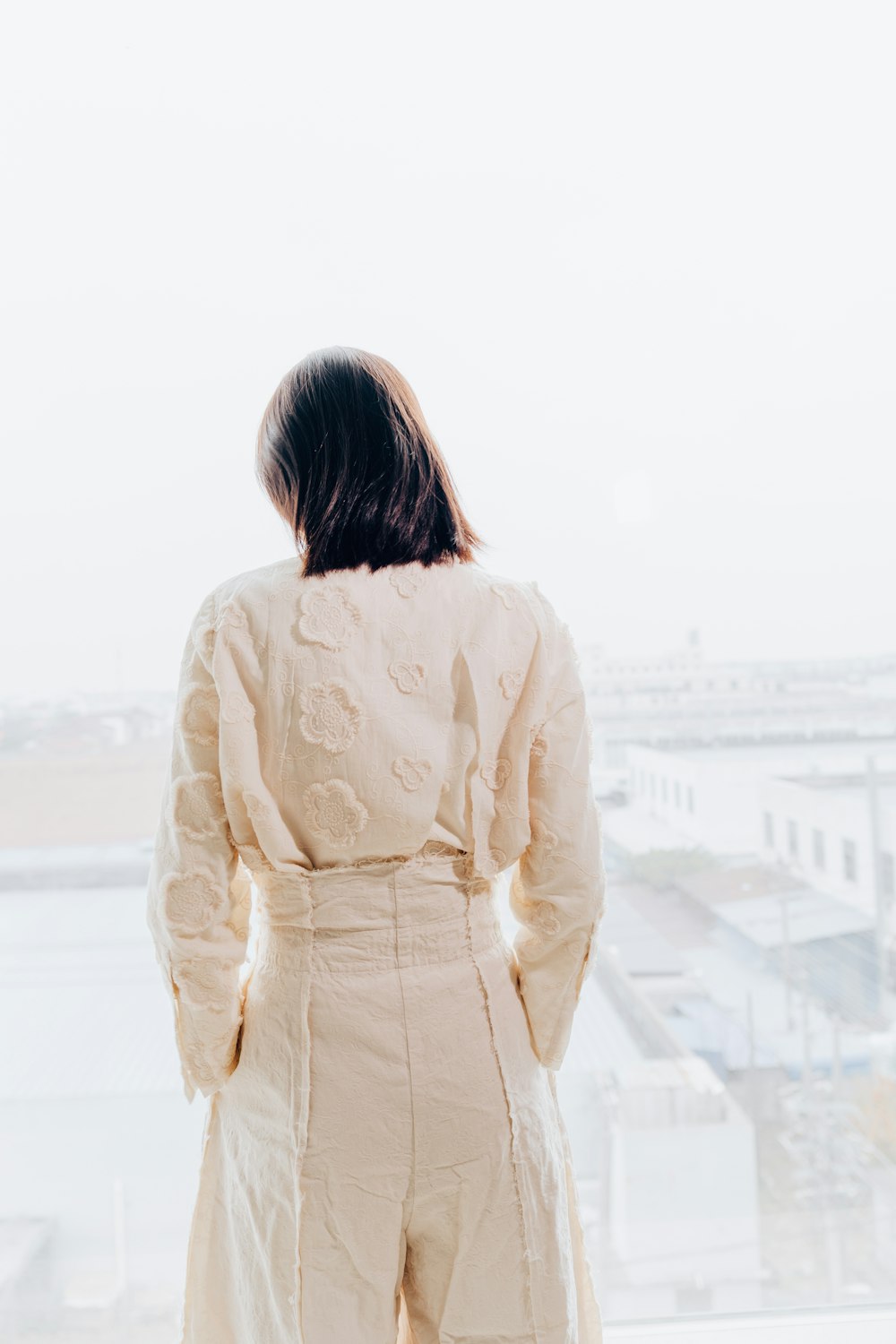 woman in white long sleeve shirt standing on white sand during daytime